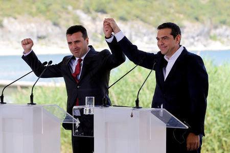 FILE PHOTO: Greek Prime Minister Alexis Tsipras and Macedonian Prime Minister Zoran Zaev gesture before the signing of an accord to settle a long dispute over the former Yugoslav republic's name in the village of Psarades, in Prespes, Greece, June 17, 2018. REUTERS/Alkis Konstantinidis/File Photo